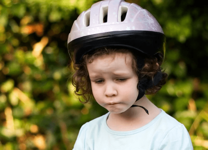 Foto de un/a niño/a de unos 7 años, con cara triste.