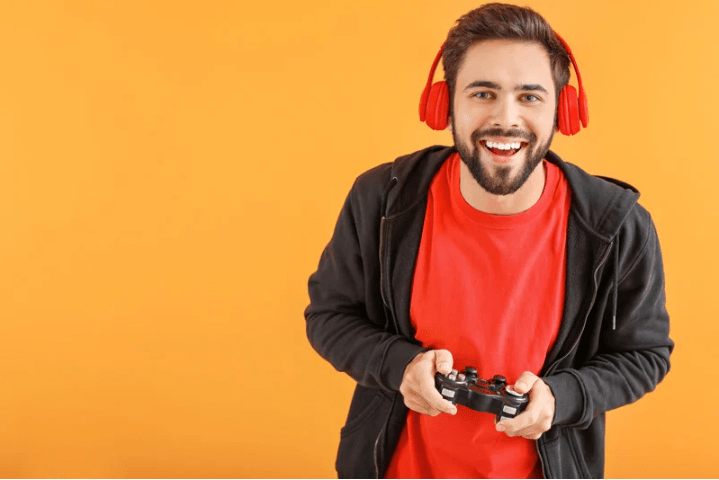 Un hombre con un mando de videojuegos y cascos.