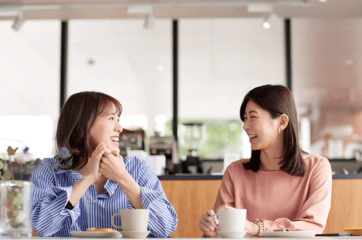 Dos jóvenes charlando en una cafetería.