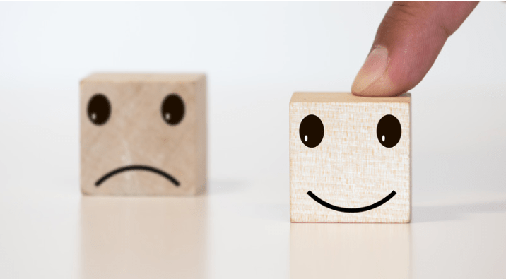 Un cubo de juguete feliz, y otro triste.