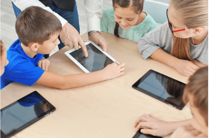 Un grupo de niños alrededor de tres tablets