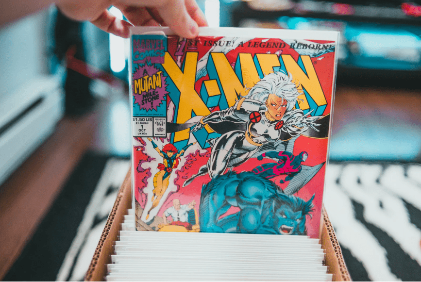 Una mano sacando de una caja un cómic de X-men.