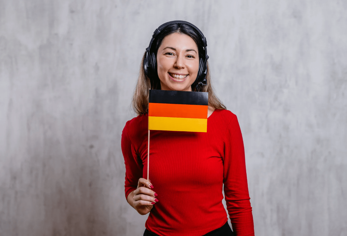 Una mujer con cascos sujetando una bandera de alemania.