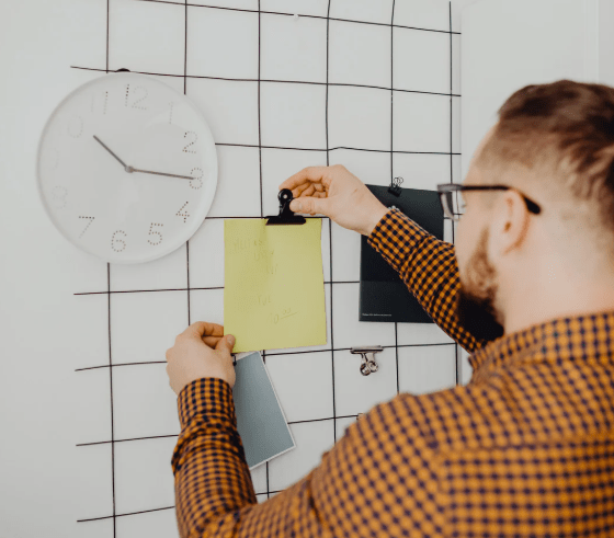 Un joven colocando una nota en la pared.
