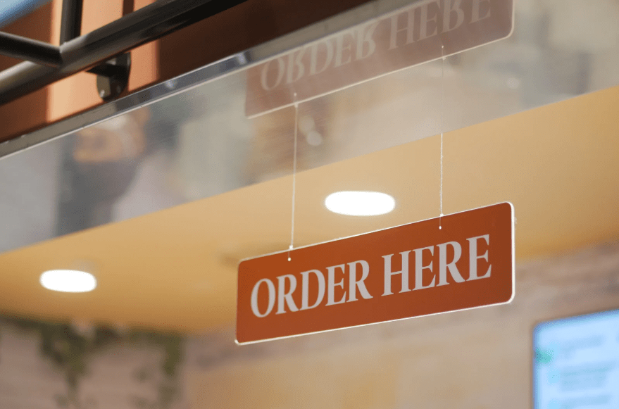 Un cartel colgante que reza "order here"