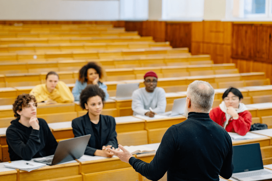 Una clase universitaria con algunos jóvenes y un profesor.