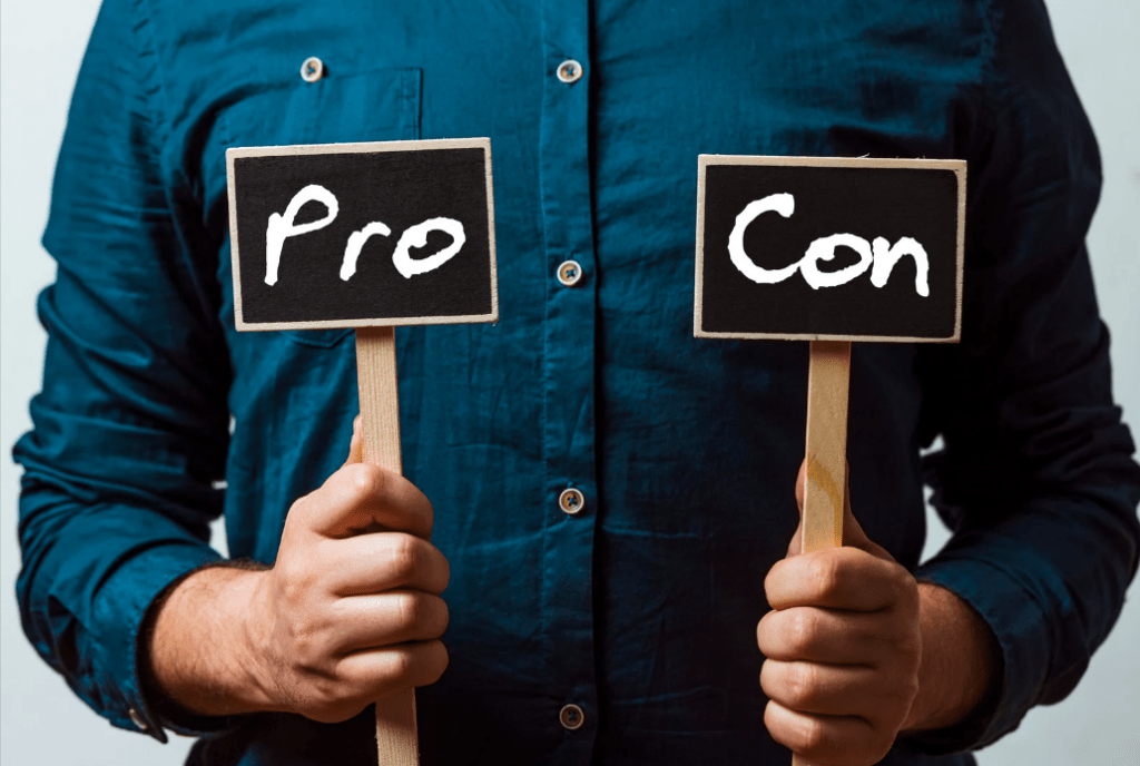 Una persona sujetando dos carteles con cada mano: uno reza "Pro", y otro "Con".