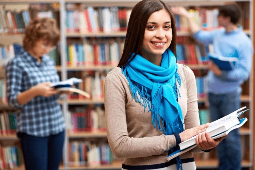 Tres jóvenes en una biblioteca universitaria