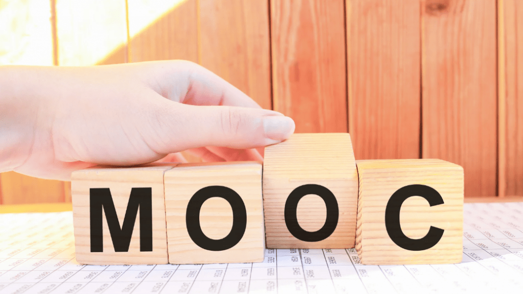 Una mano deletreando la palabra "MOOC" con bloques de madera.