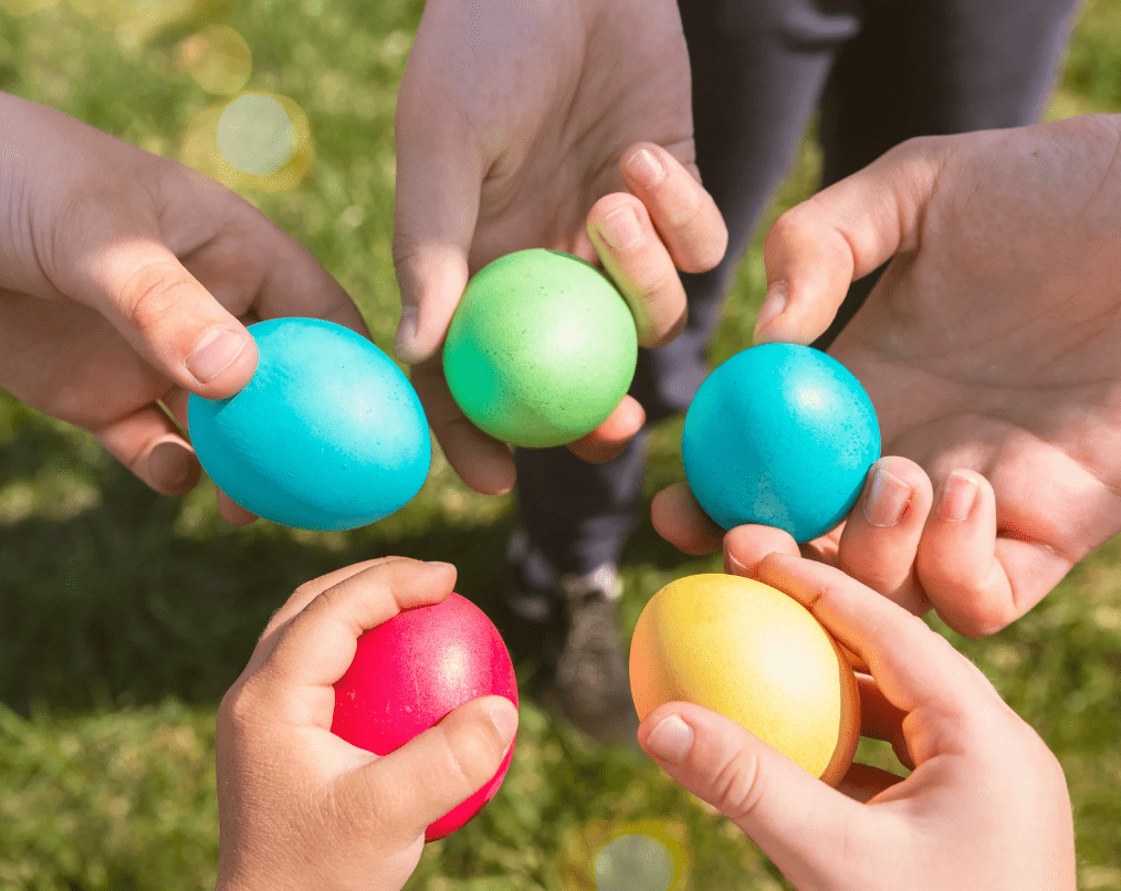 cinco manos sujetando cinco huevos de colores.