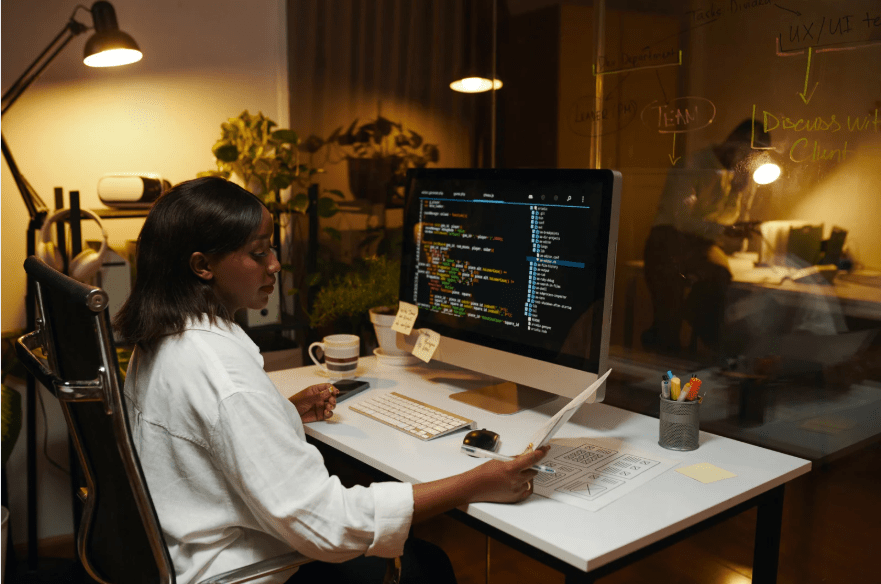 Una joven trabajando con un ordenador en programación.